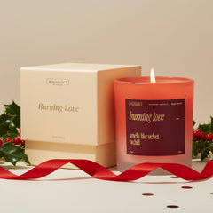 Lifestyle shot of Burning Love candle on a coffee table with roses