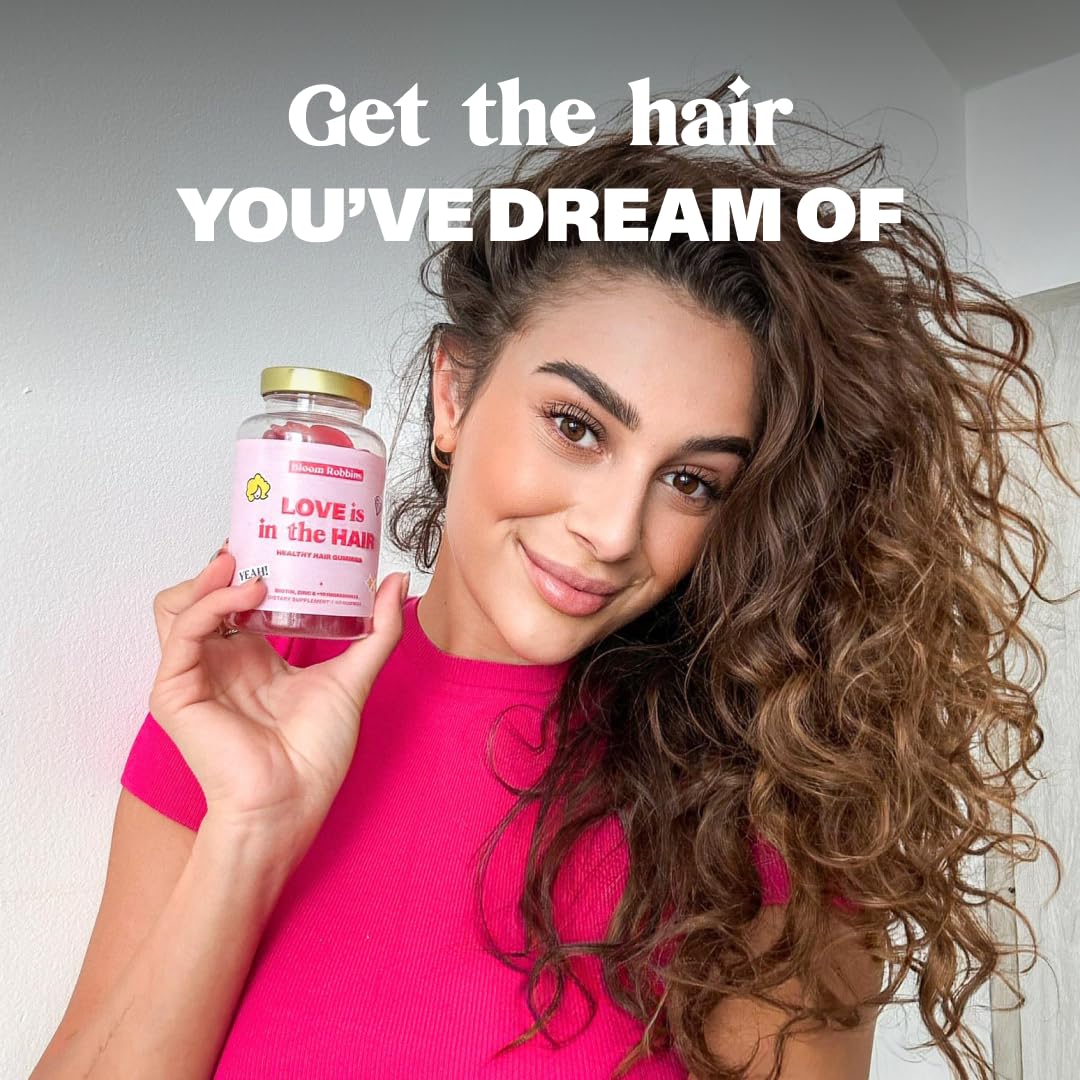 Woman with long healthy hair holding Bloom Robbins Gummies