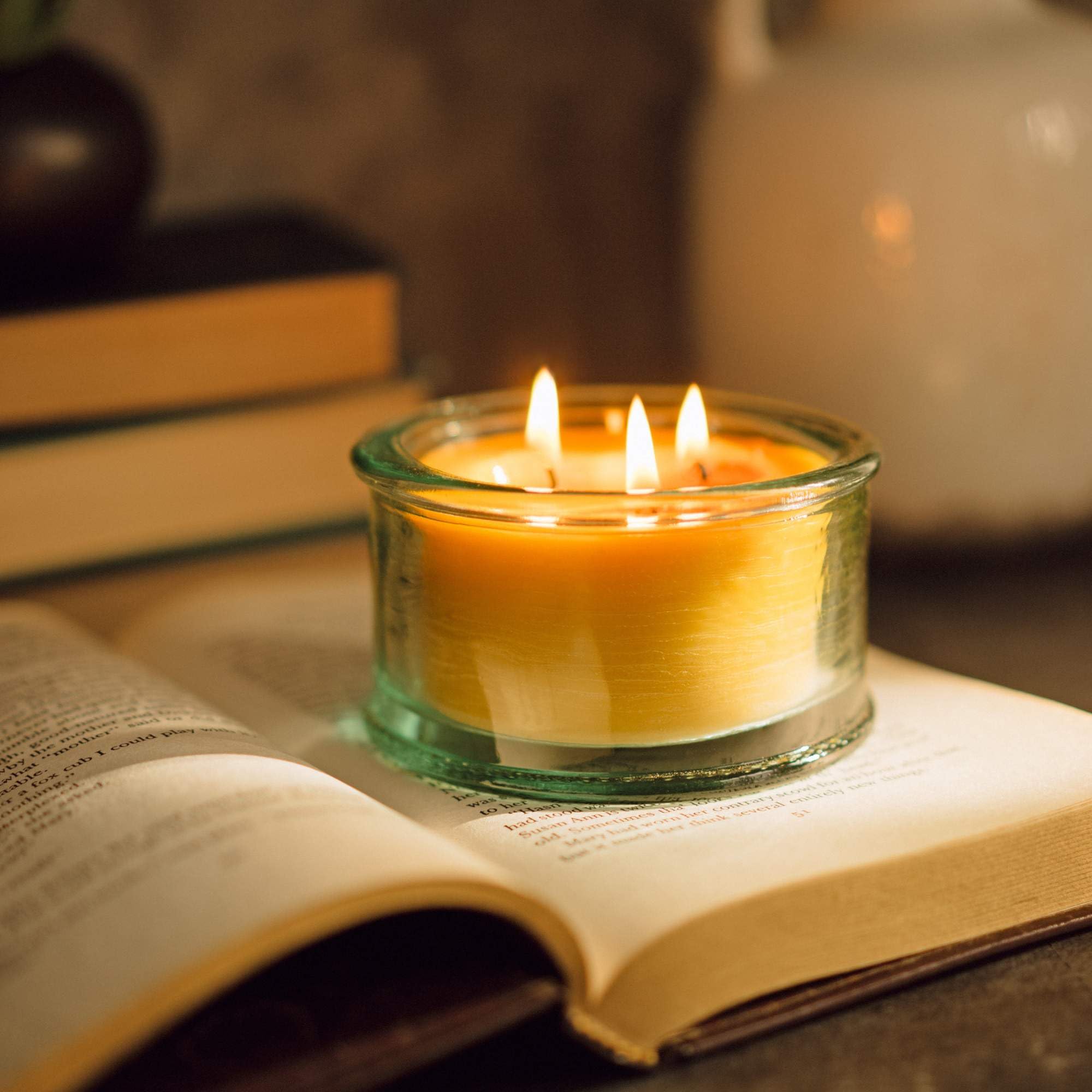 Spruce scented beeswax candle in clear glass jar