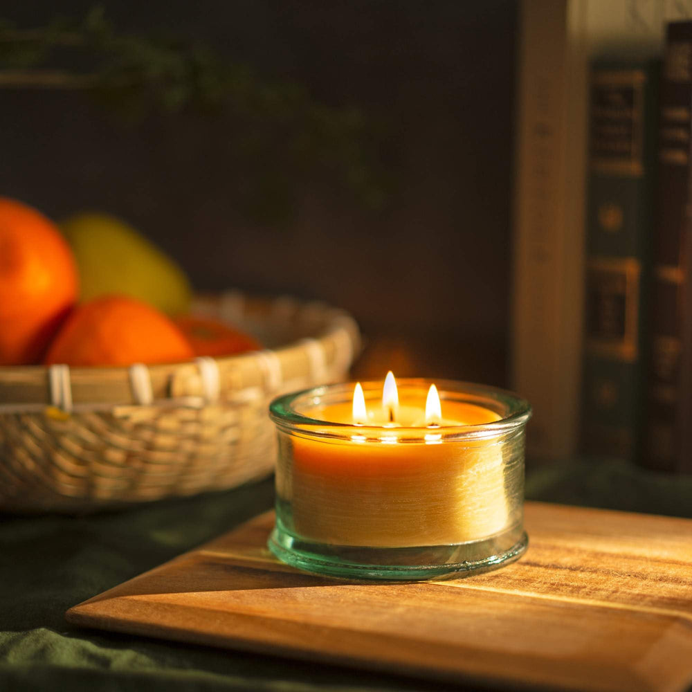 Beeswax candle burning evenly in a clear glass jar