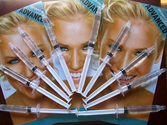 Gel being dispensed from a whitening syringe into a tray