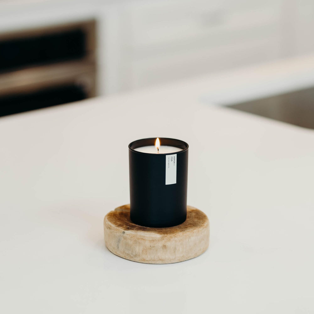 Ambient lit scene featuring the Aspen & Fog candle in a cozy room.