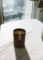 Top-down view of the candle inside the black tumbler, wax surface visible.