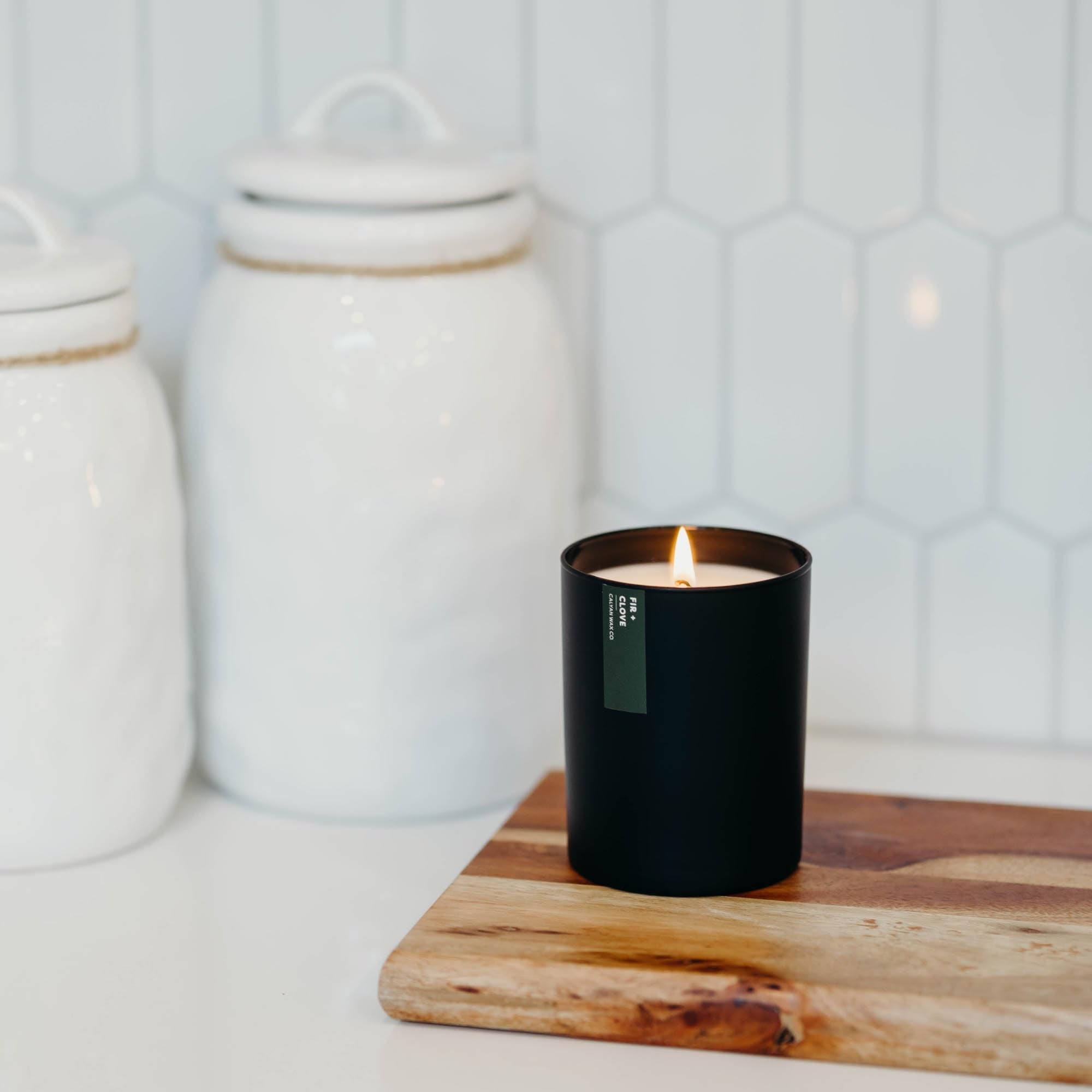 Candle on a wooden surface with pine notes