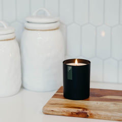Candle on a wooden surface with pine notes
