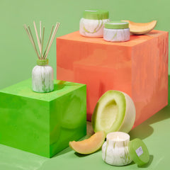 Close-up of Capri Blue Honeydew Crush reed diffuser set in marble vase
