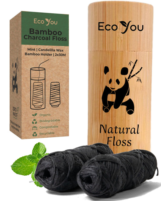 Charcoal bamboo floss spools inside a reusable bamboo container
