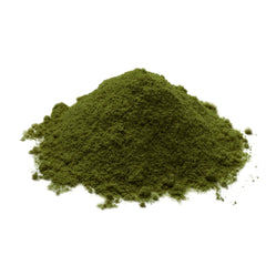 Chlorella powder being poured to show vibrant green color