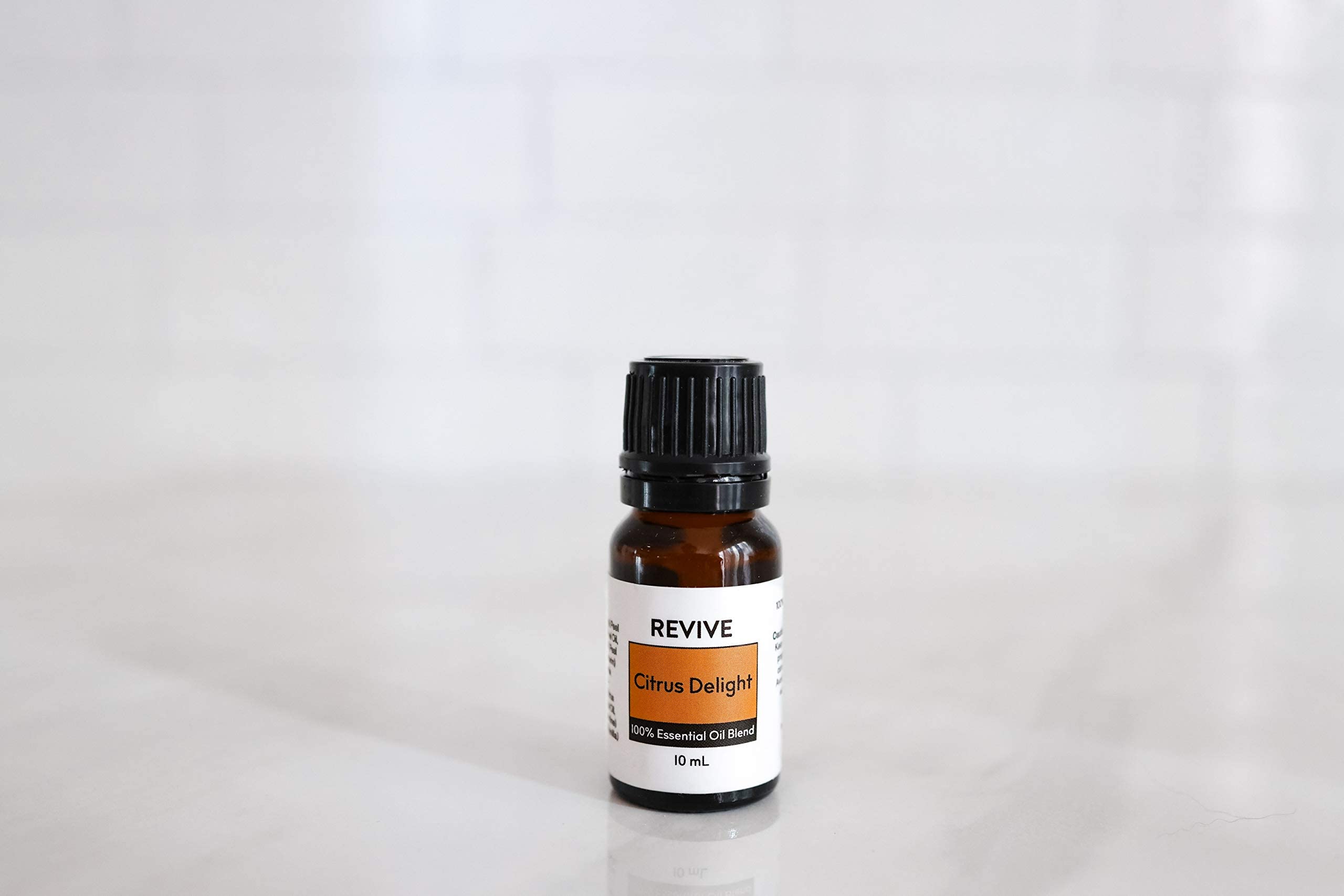 Close-up of citrus fruits and Citrus Delight essential oil bottle