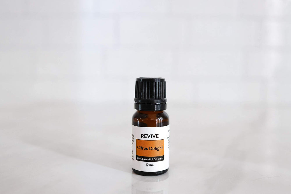 Close-up of citrus fruits and Citrus Delight essential oil bottle