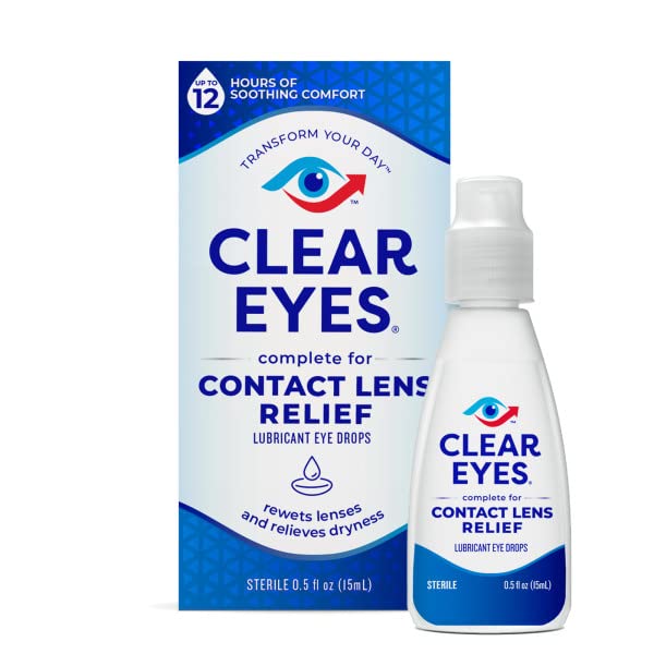 Hands applying eye drops while wearing contact lenses