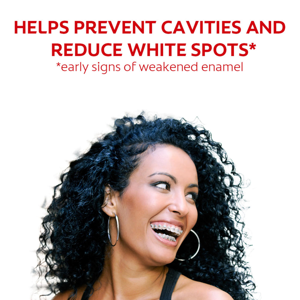 Person using mouthwash with braces