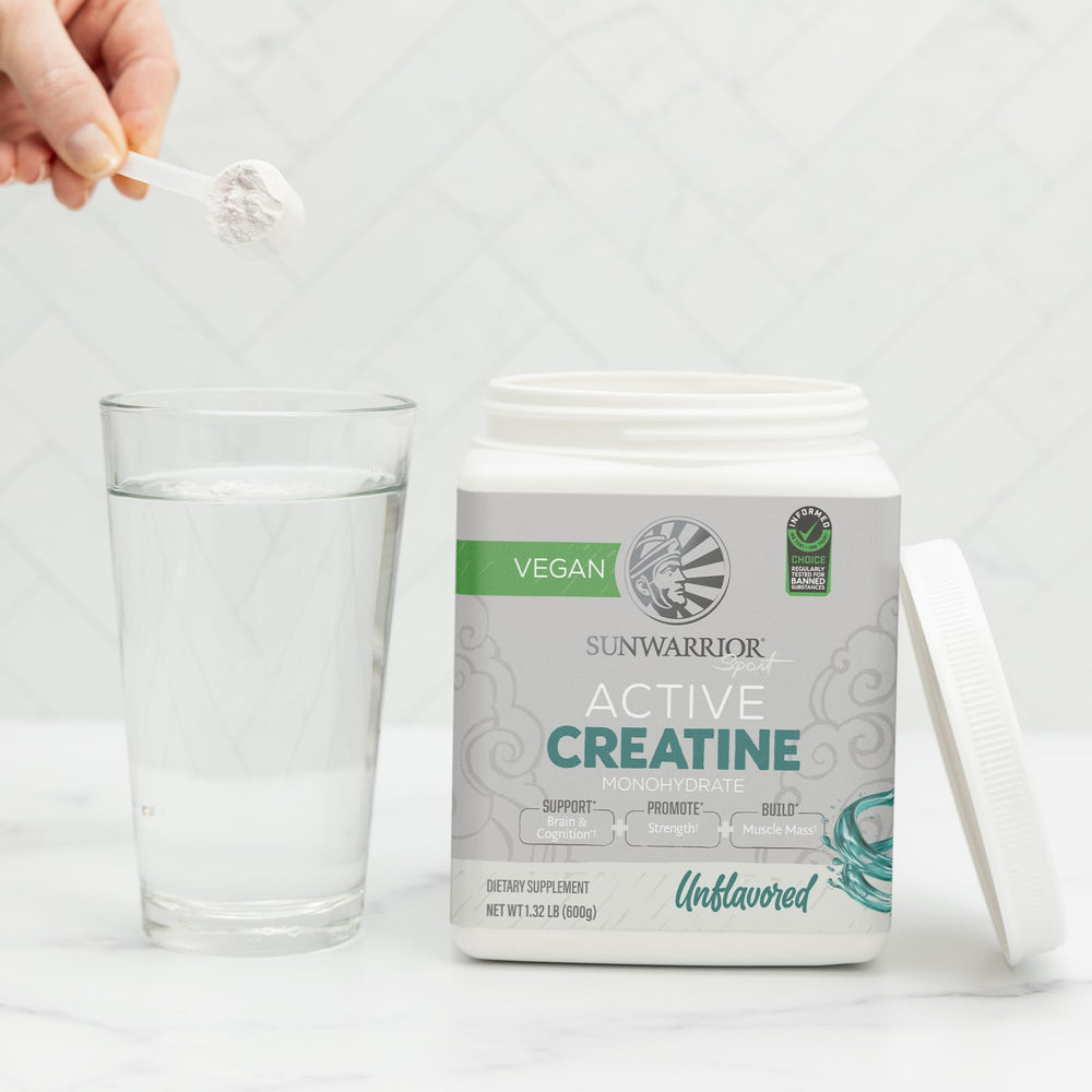 Scoop of creatine powder being poured