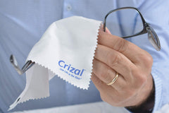 Glasses being cleaned with Crizal microfiber cloth on AR-coated lenses