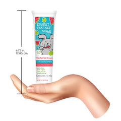 Desert Essence tube next to child toothbrush demonstrating 4.7 oz scale