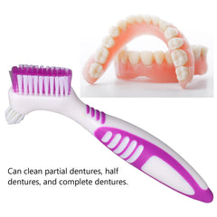Manual denture cleaning brush in use