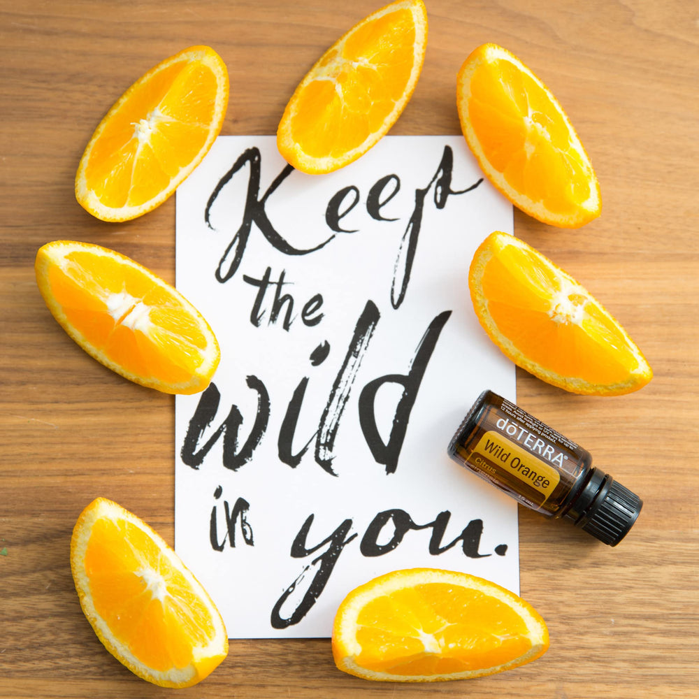 Flat lay of doTERRA Wild Orange essential oil with citrus