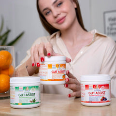 Scoop of Gut Assist powder ready to mix for gentle digestive support.
