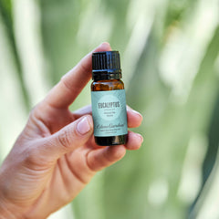 Dropper bottle beside eucalyptus leaves