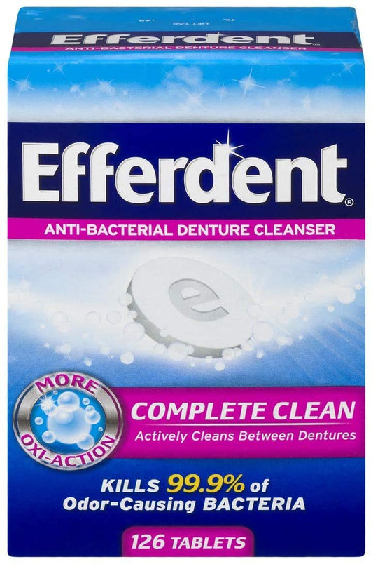 Efferdent Anti-Bacterial Denture Cleanser tablets dissolving in a glass of water