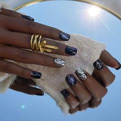 FURNUNUBI cat-eye nails highlight purple tones and gothic chrome accents for dramatic looks.