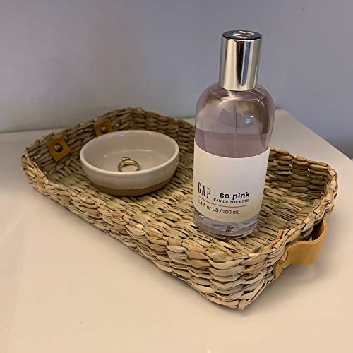 Lifestyle shot of GAP SO PINK bottle with flowers on a pink backdrop