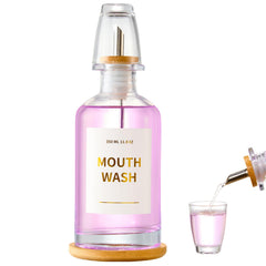 Glass mouthwash dispenser on a bamboo tray for bathroom decor