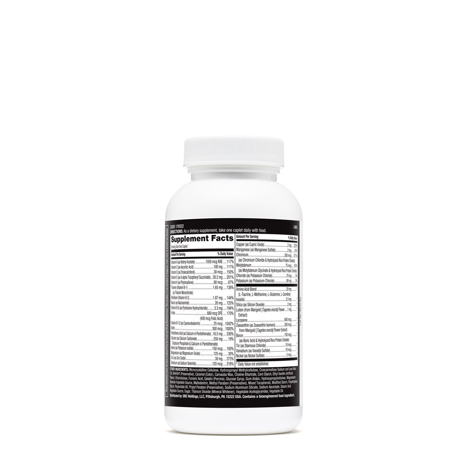 Multivitamin tablets spilled beside the bottle on white background