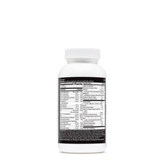 Multivitamin tablets spilled beside the bottle on white background