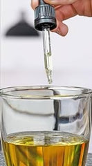 Full 59 ml bottle of Gold Heal beside a measurement