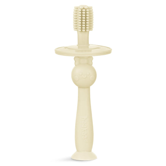 Cream Haakaa infant toothbrush with 360° bristle coverage
