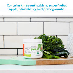 Serving scoop with HeartGreens powder in a glass of water