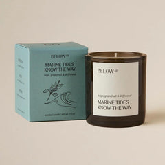 Candle burning with coastal sage, grapefruit, and driftwood notes