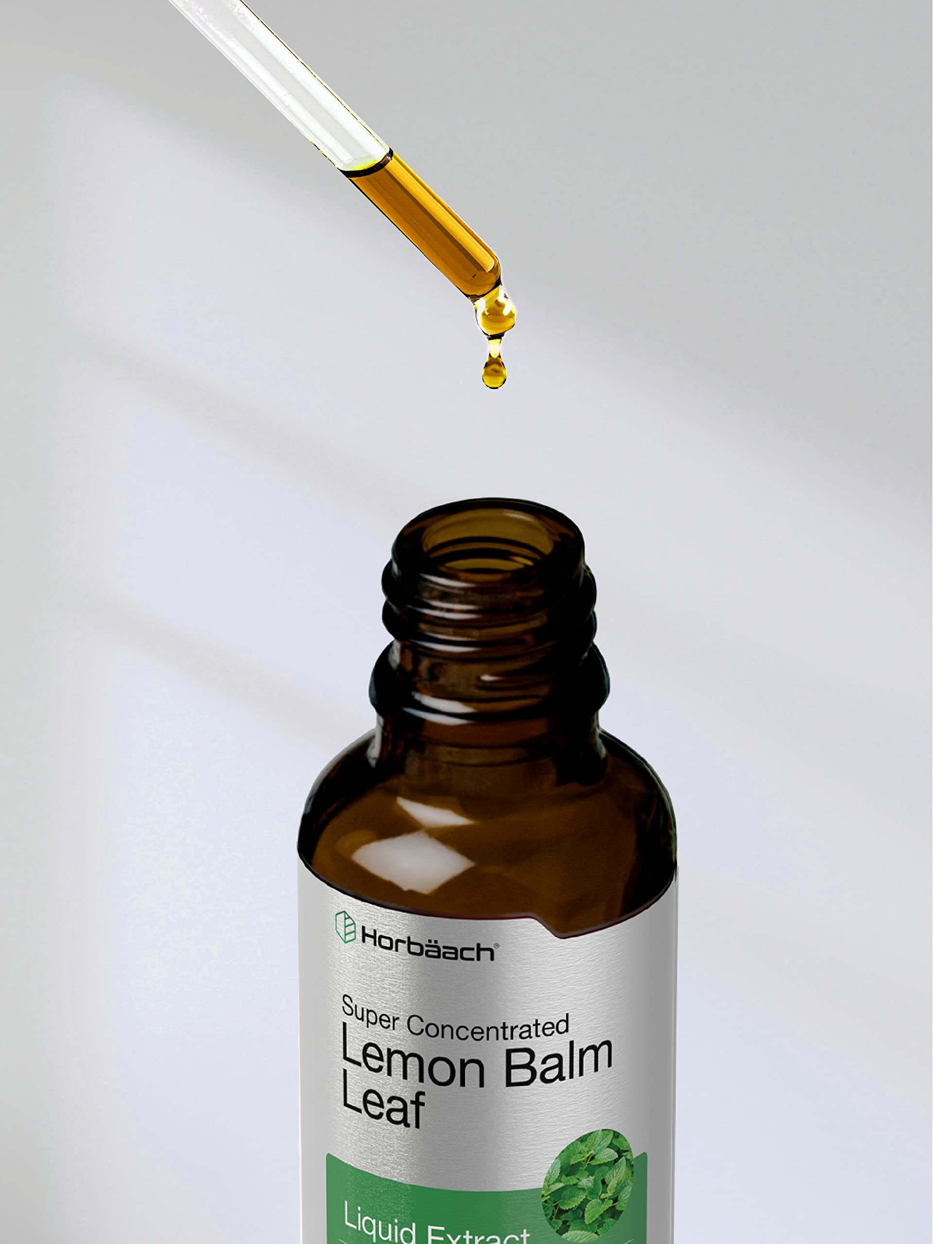 Lemon balm tincture bottle with dropper on white background