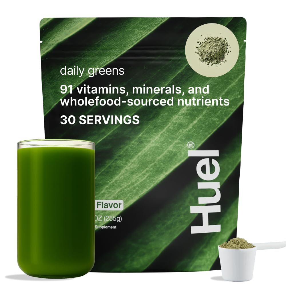 Huel Daily Greens tub with scoop on kitchen counter