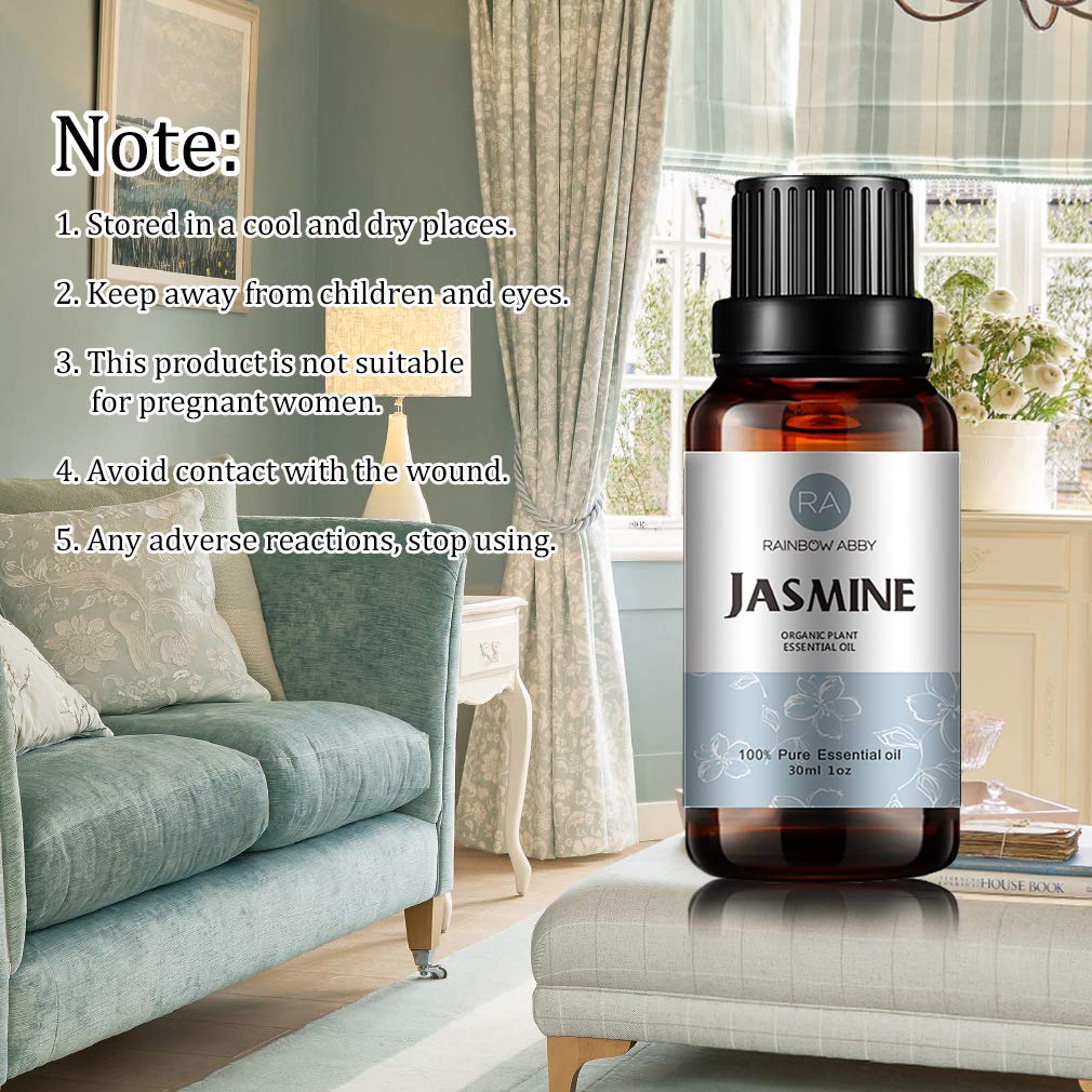 Fresh jasmine flowers beside a bottle of jasmine oil