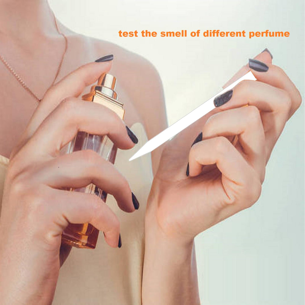 Joysorn perfume test strips being dipped to sample a fragrance.