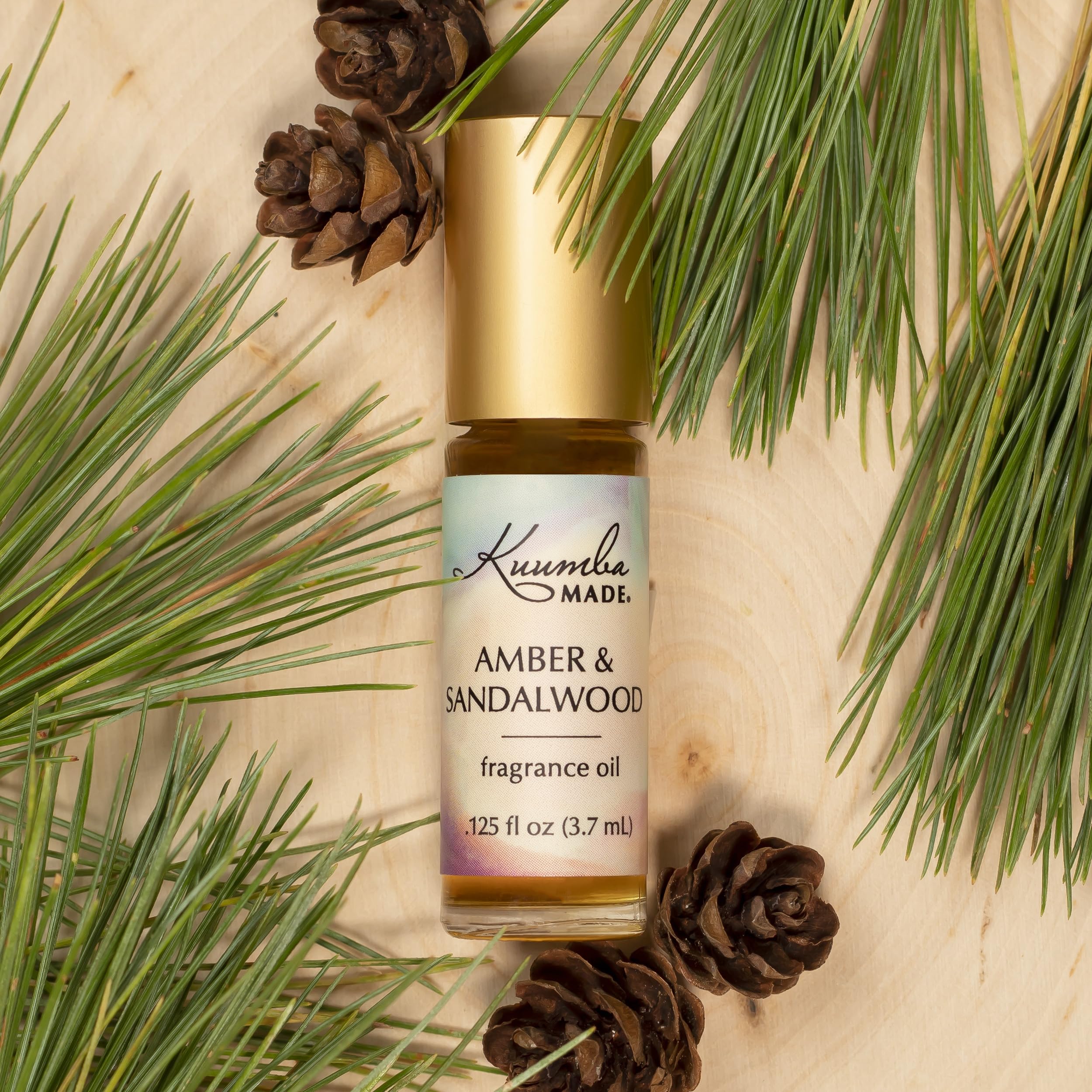 Kuumba Made Amber and Sandalwood roll-on cap close-up highlighting premium design.