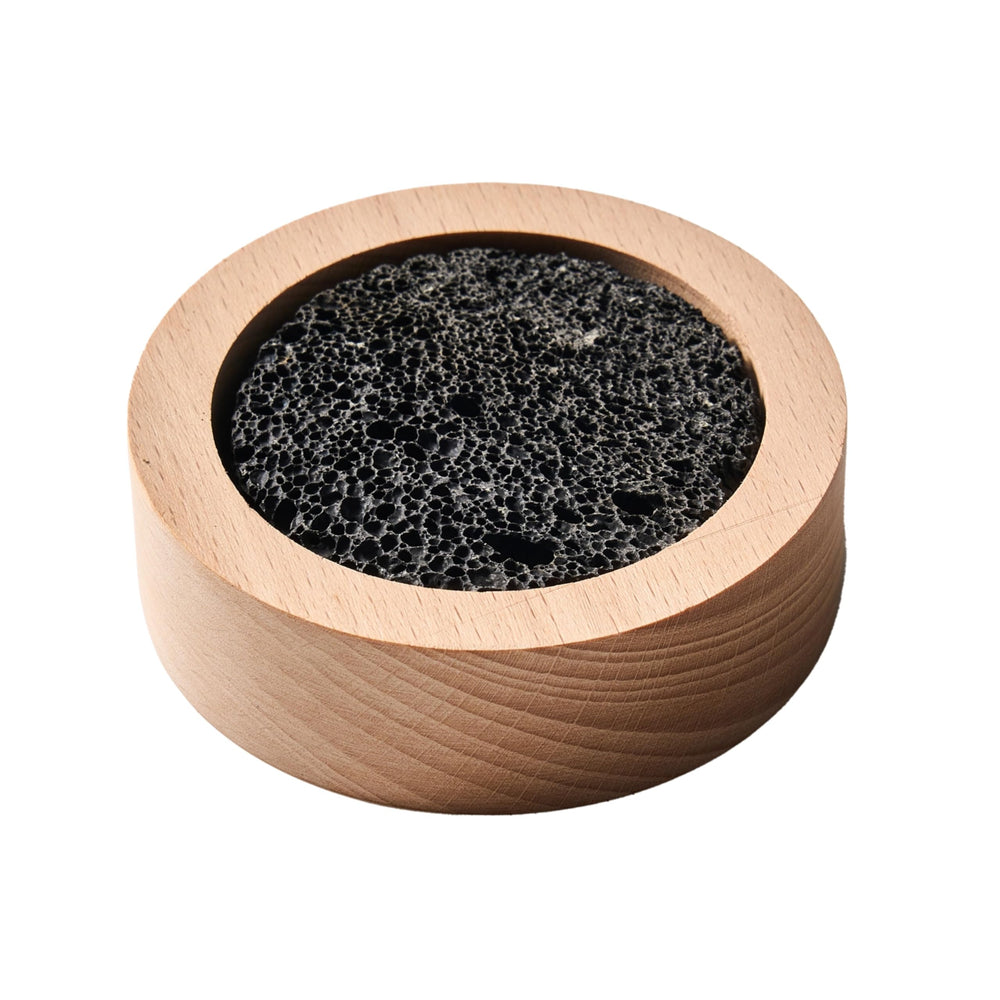 Lava rock diffuser on a wooden base placed on a desk