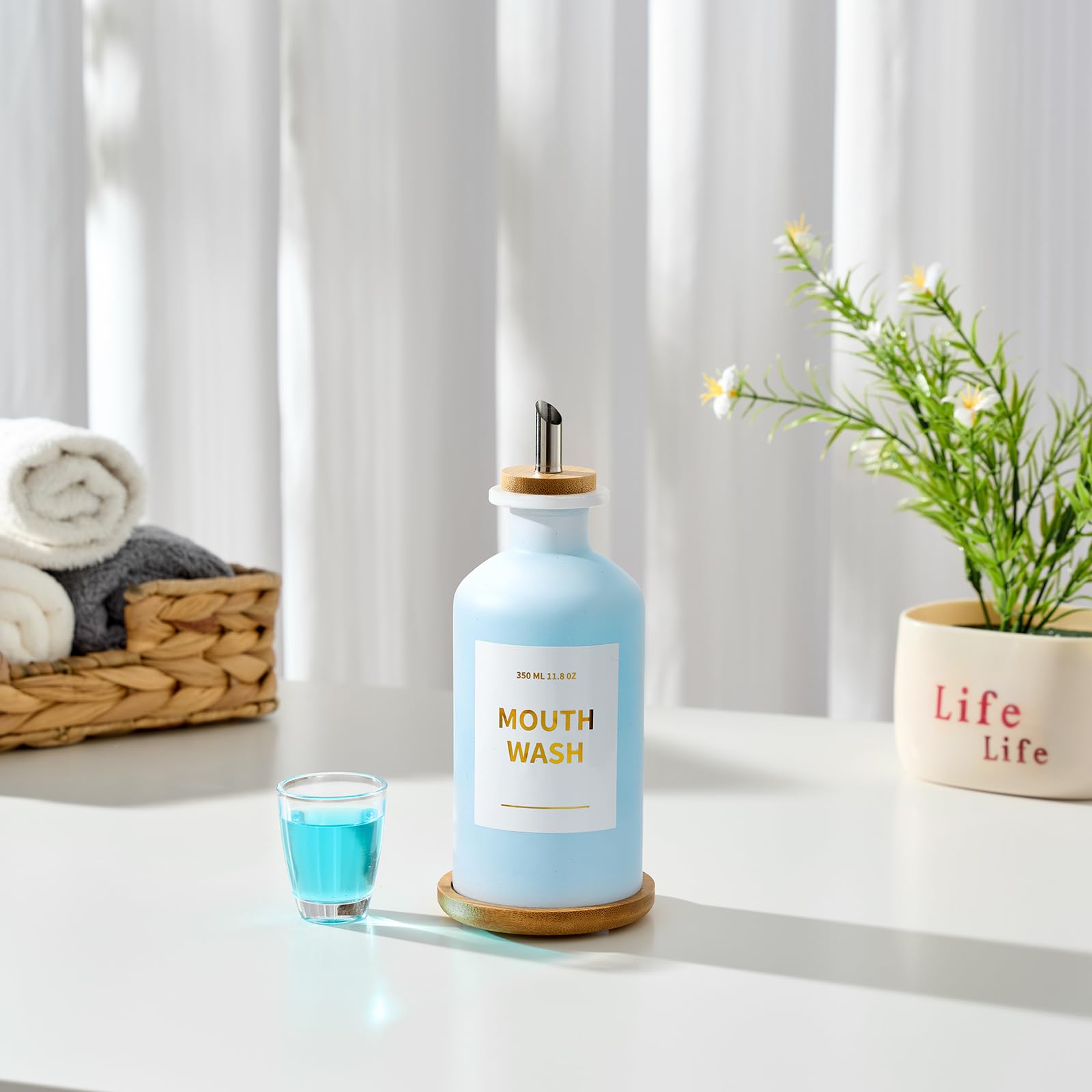Minimalist bathroom display featuring white glass and bamboo tray