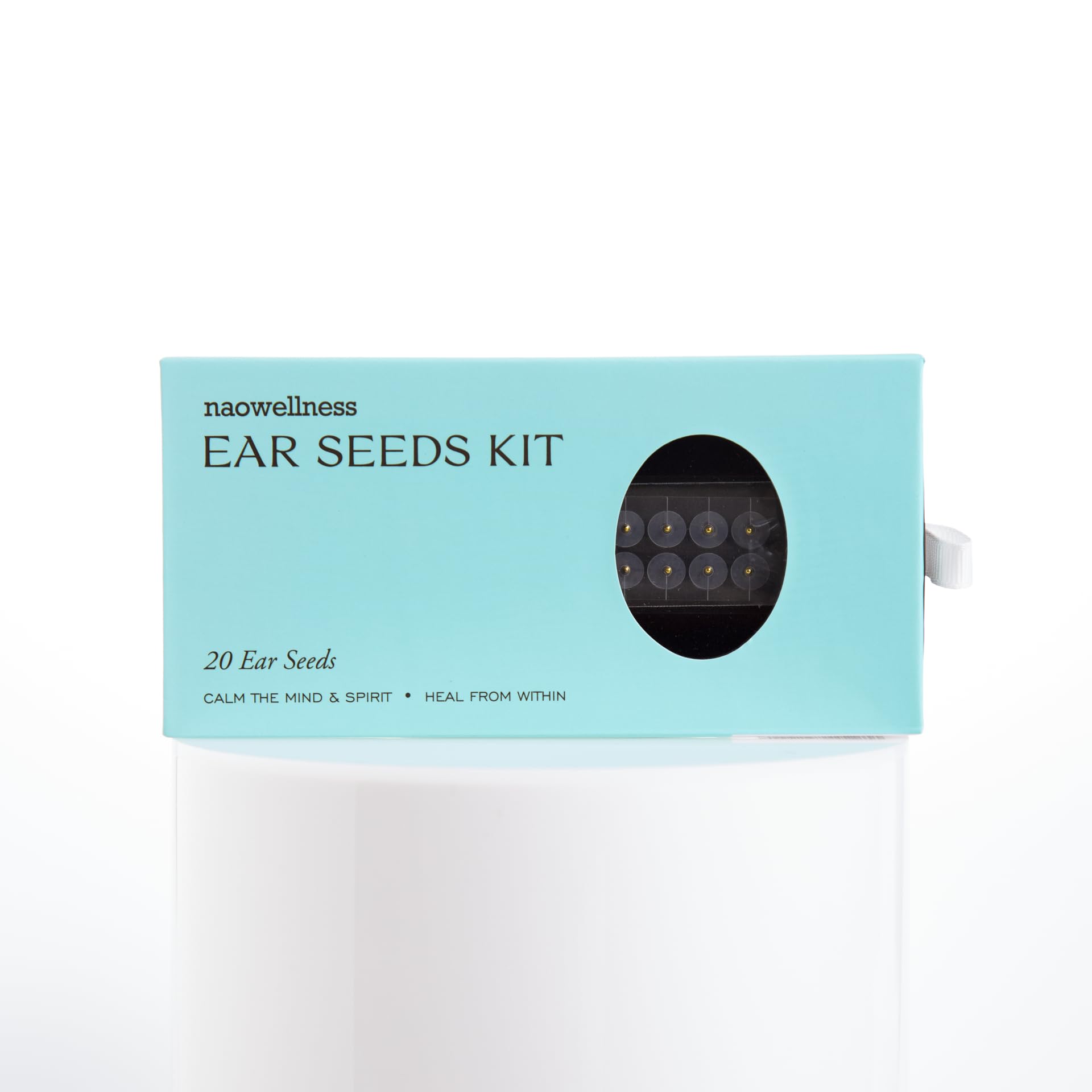 Close-up of 24K gold ear seeds and adhesive beads