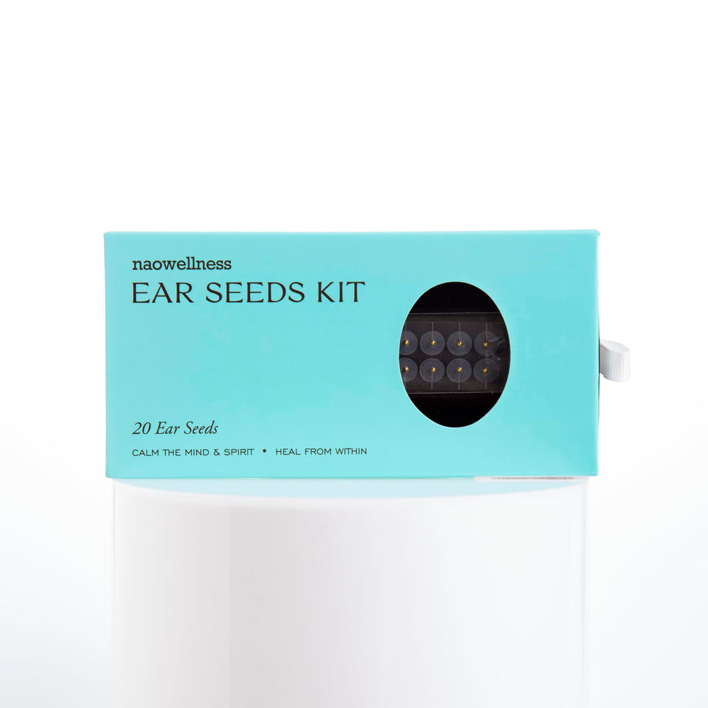 Close-up of 24K gold ear seeds and adhesive beads