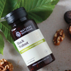 Black walnut capsules displayed beside the bottle
