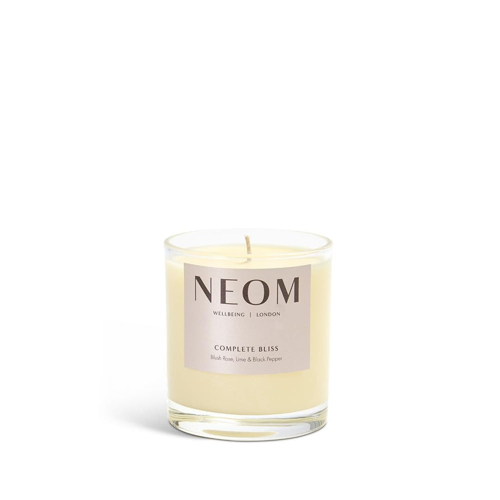 Neom Complete Bliss candle blush rose jar closeup highlights luxurious scent for de-stressing rituals.