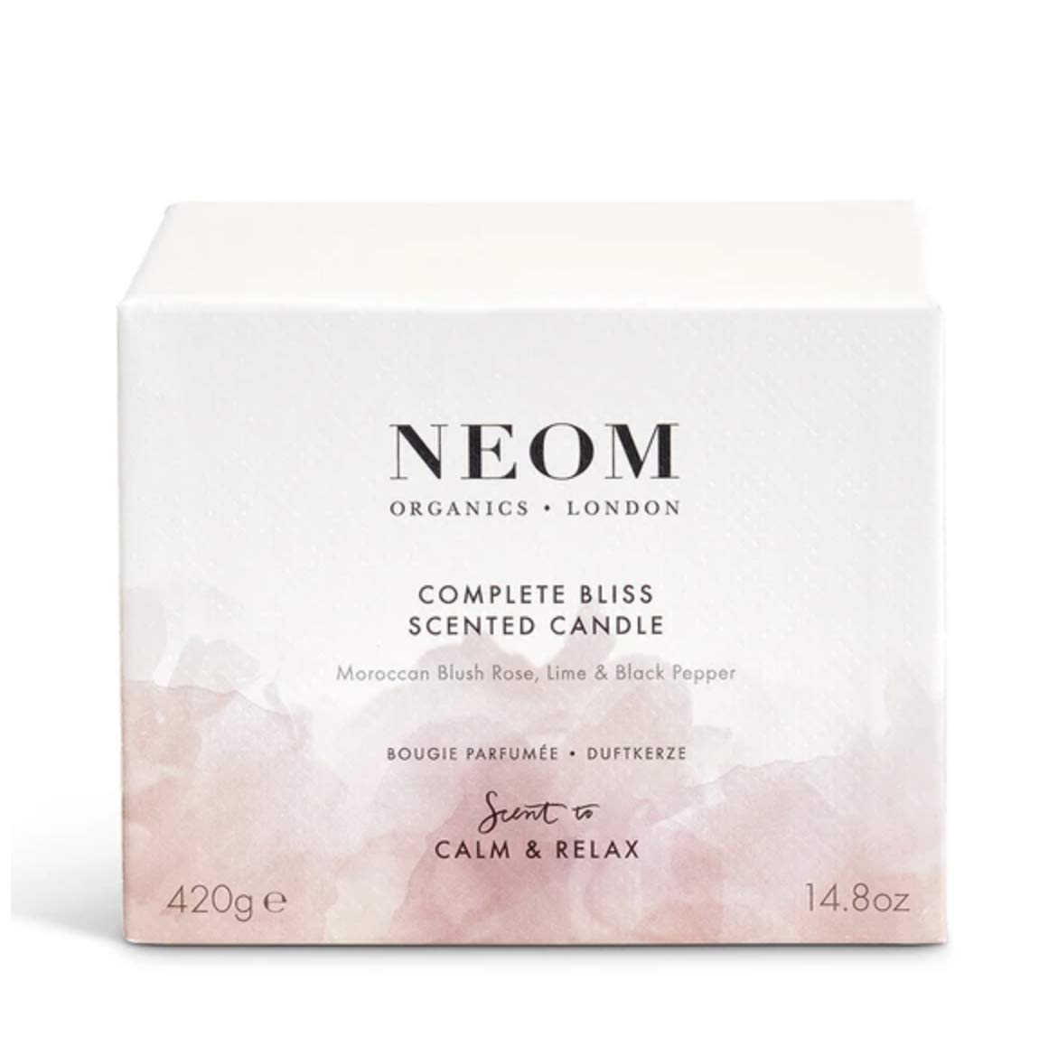 NEOM Complete Bliss candle burning in a cozy living room setting.