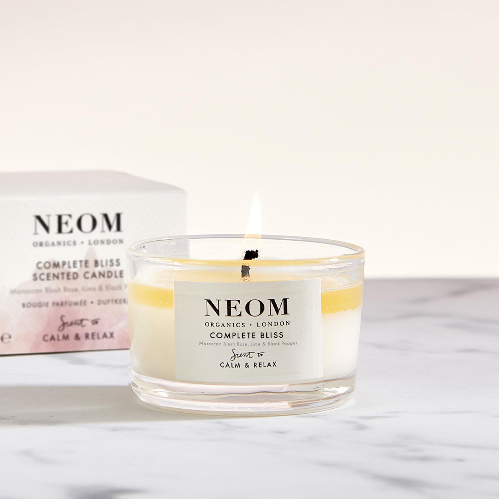 NEOM Complete Bliss travel candle packaging highlights premium wellbeing in a compact design.