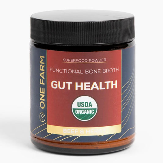 Hero shot of One Farm Gut Health powder bottle with fresh ingredients