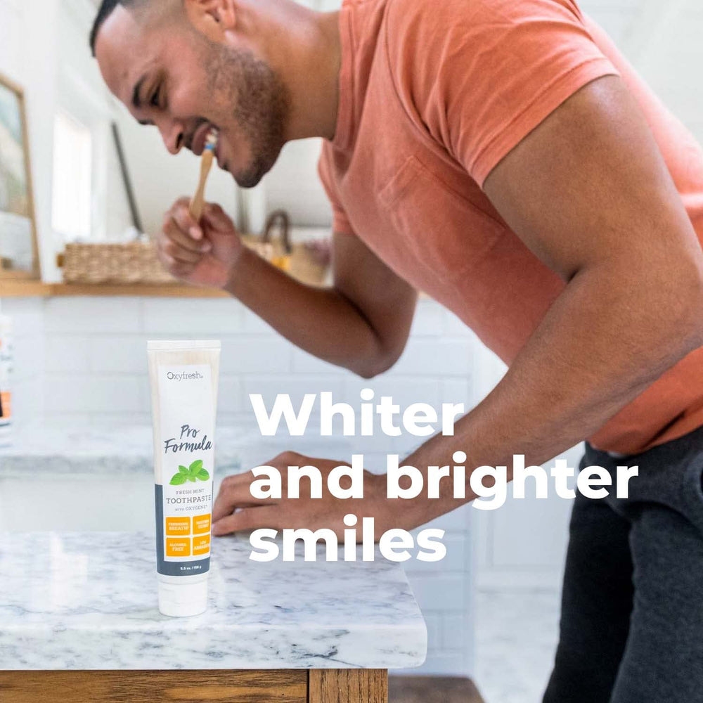 Close-up of smiling person with sensitive teeth using toothpaste