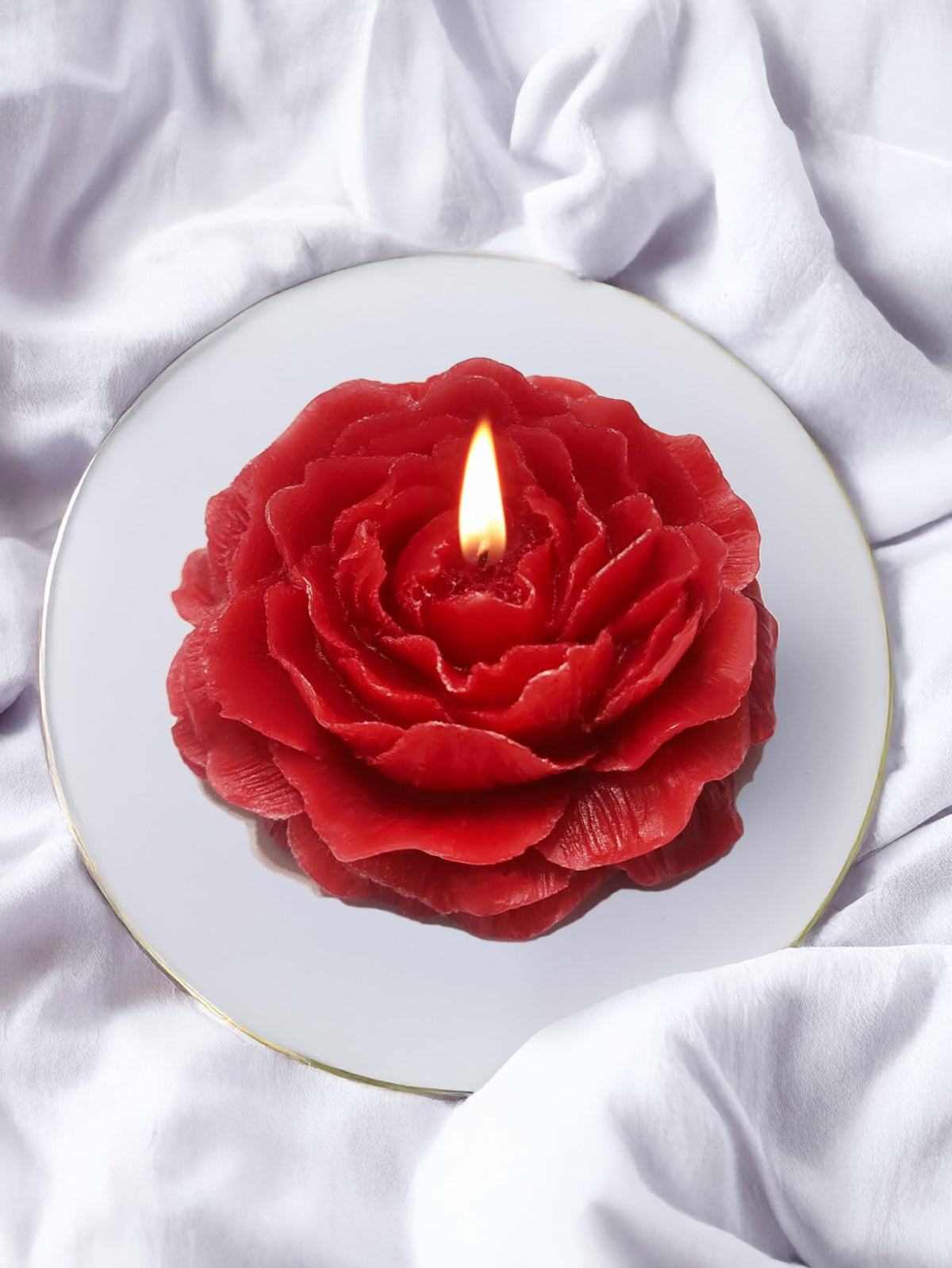 Red Peony flower-shaped candle on a clean surface