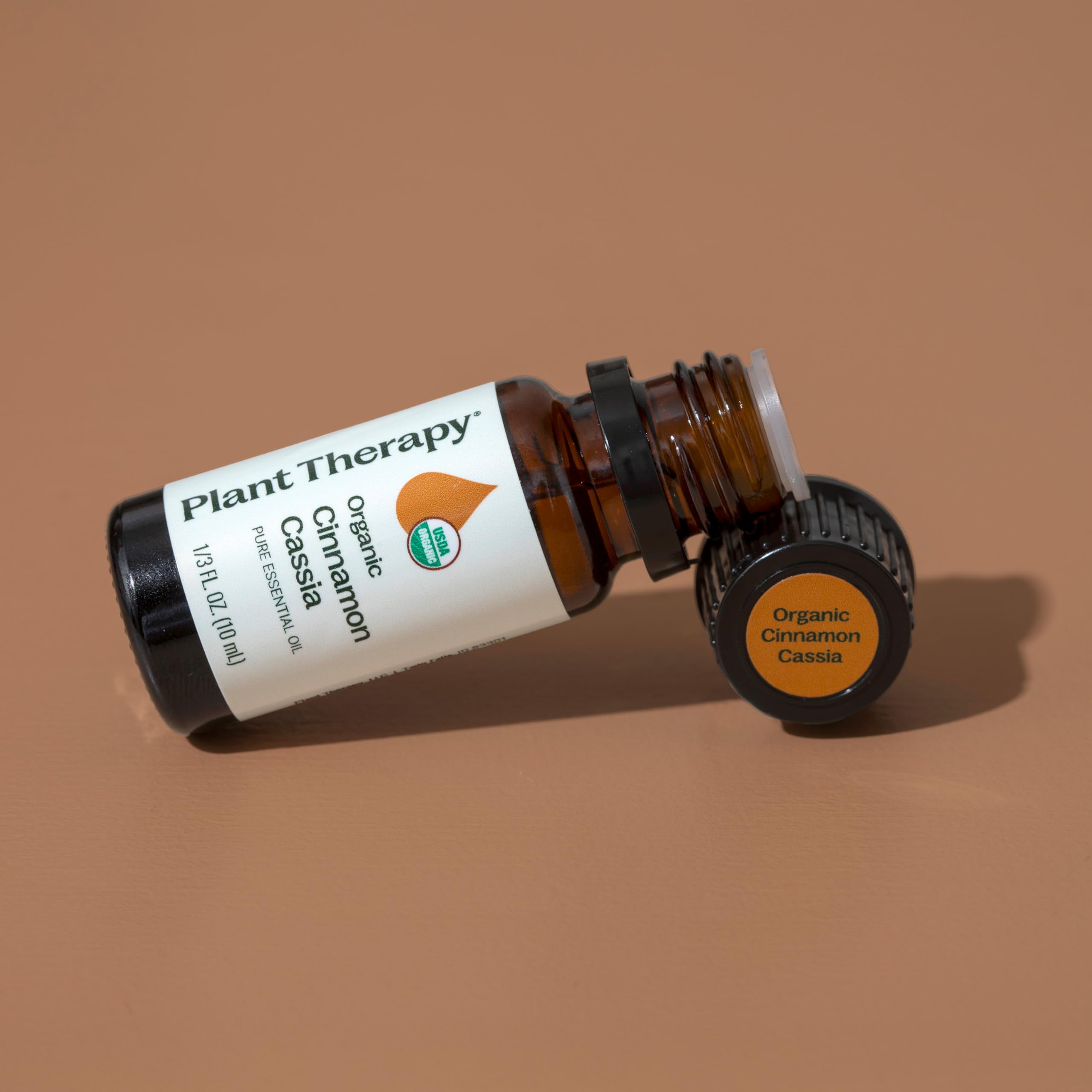Essential oil bottle with dropper and cinnamon sticks